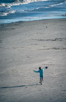 Child joyfully running on a serene beach, capturing a moment of freedom and play by the sea.