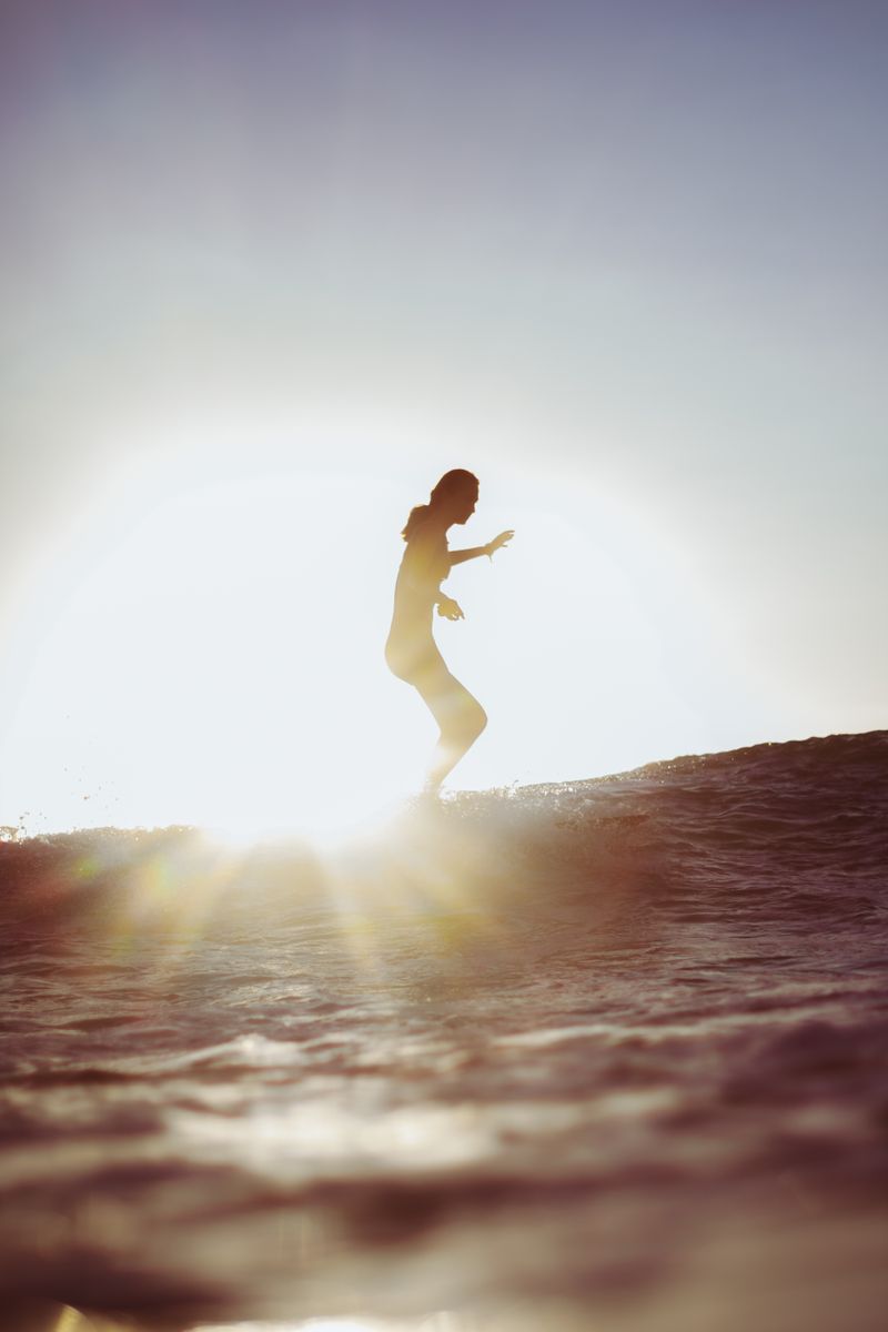 Surfer riding a glowing wave at sunset