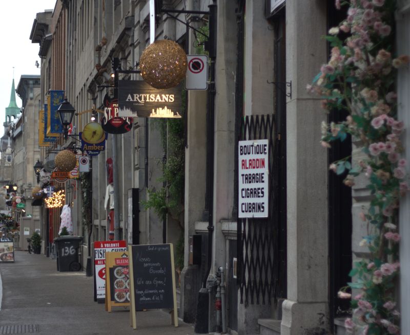 Charming cobblestone street with shops and signs in Old Montreal