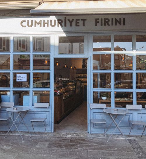Free Cozy bakery with blue facade and outdoor seating area in a quaint town. Stock Photo