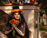 A Catrina with face paint and flowers celebrating Dia de los Muertos in Mexico City.