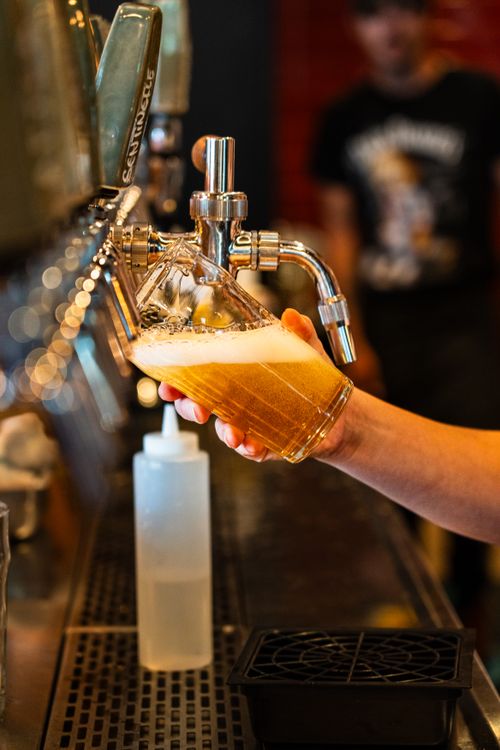 Free Close-up of frothy craft beer being poured from tap in Montreal pub. Stock Photo