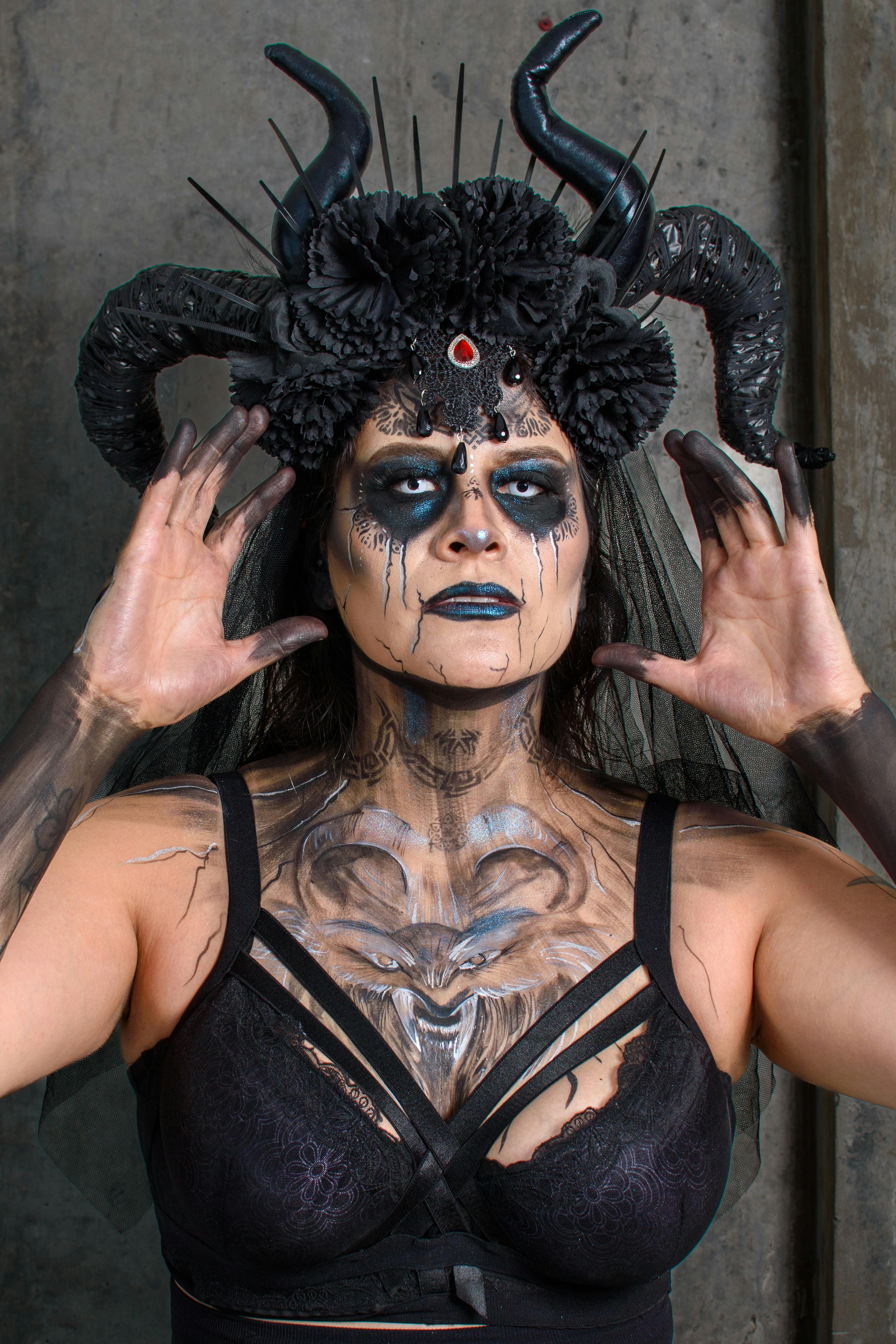 grátis Um retrato com tema gótico apresentando uma mulher com maquiagem escura e um cocar com chifres. Foto profissional