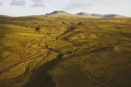 Free Capture the beauty of lush green hills and a winding river from a high vantage point. Stock Photo