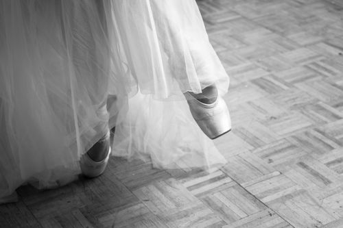 Free A graceful ballet dancer on pointe wearing a delicate tulle skirt in a studio. Stock Photo