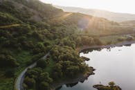 从空中俯瞰，蜿蜒的道路、日出时宁静的水面倒影与令人惊叹的山景尽收眼底
