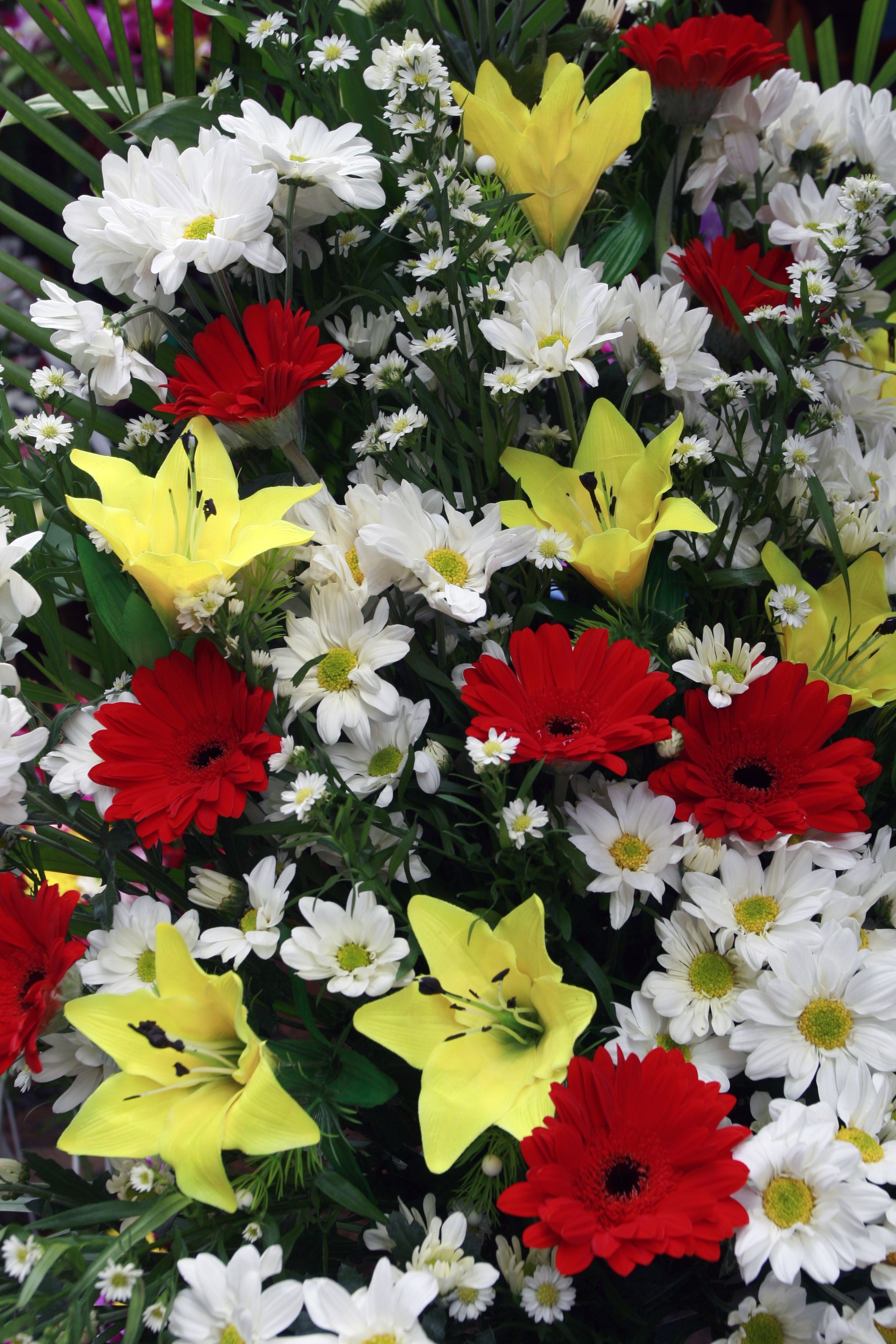 [ColoSach]-a-bright-floral-arrangement-of-daisies,-lilies,-and-gerberas-in-red,-yellow,-and-white.