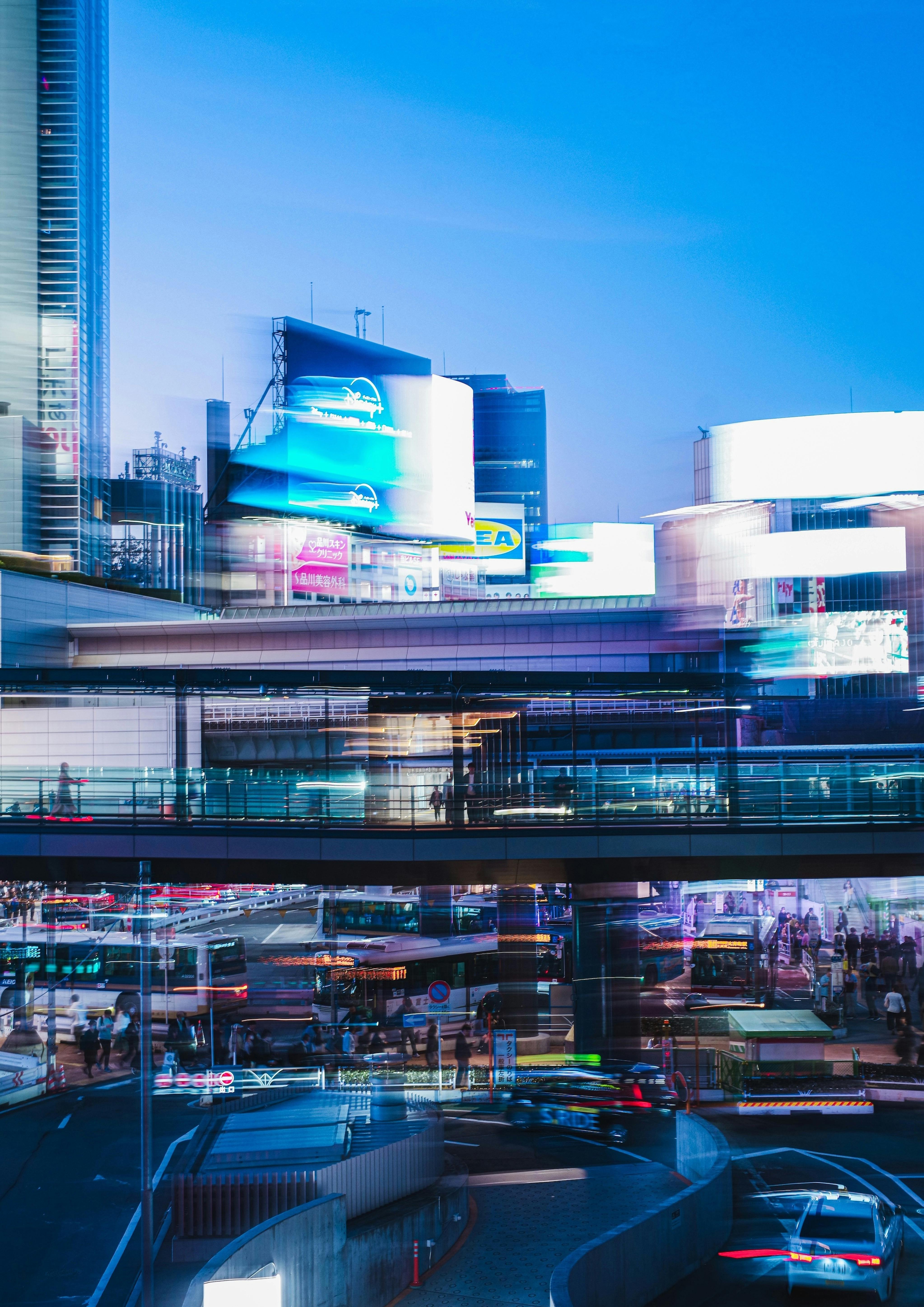 Dynamic view of Shibuya's bustling streets and illuminated billboards at twilight.