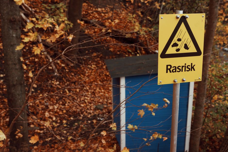 Swedish landslide risk sign amidst falling autumn leaves in Gränna, Sweden.