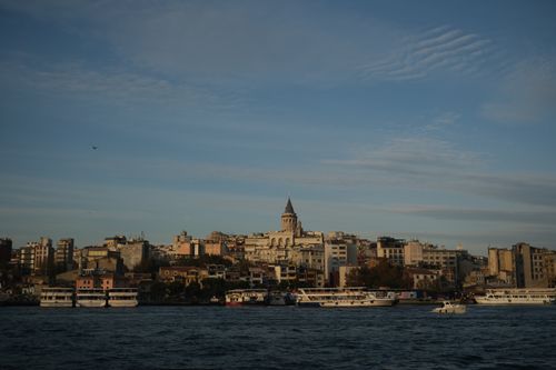 Free Scenic view of Istanbul featuring the iconic Galata Tower and Bosphorus boats at sunset. Stock Photo