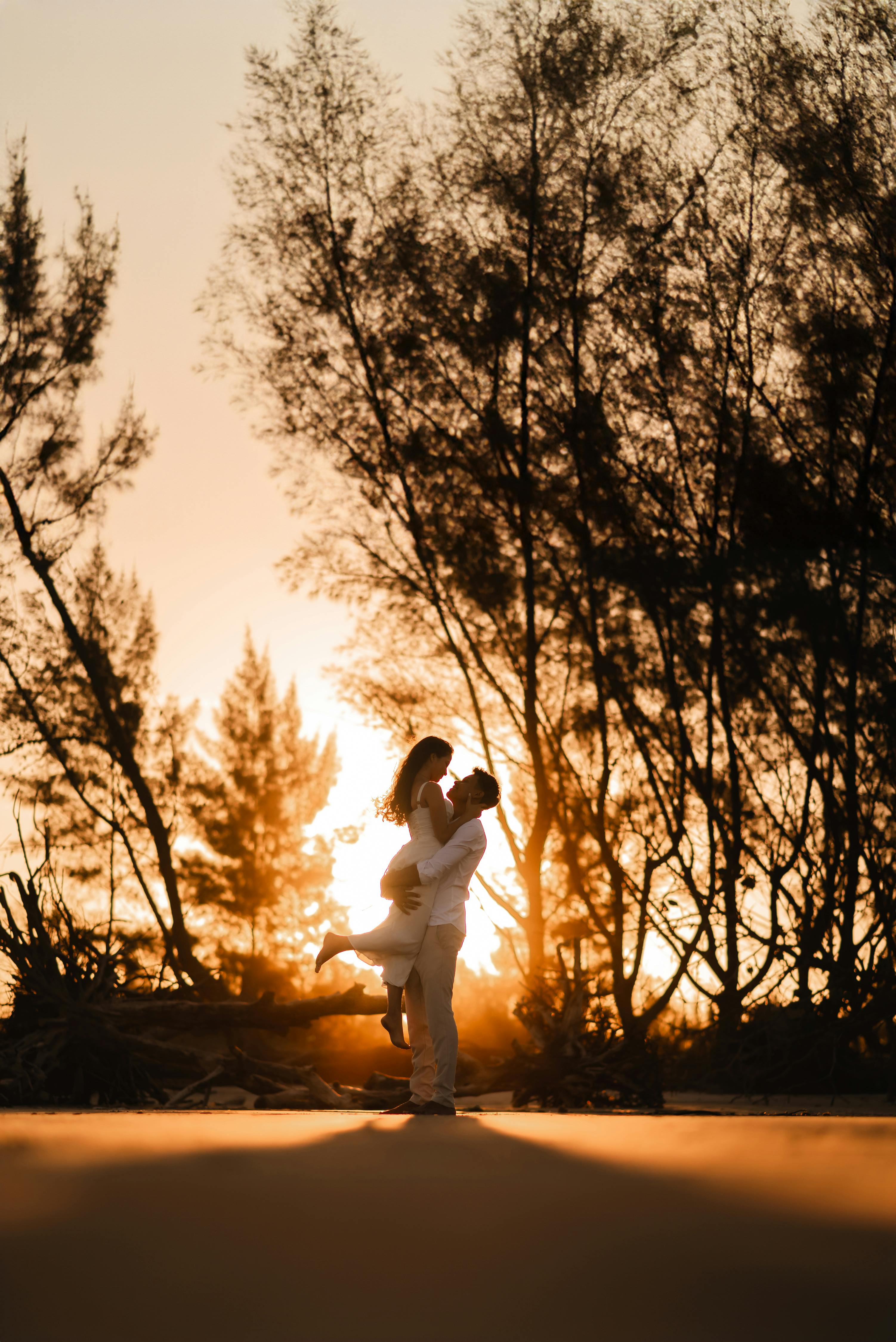 A couple shares a romantic moment at the beach during sunset in Ilha Comprida, Brazil.