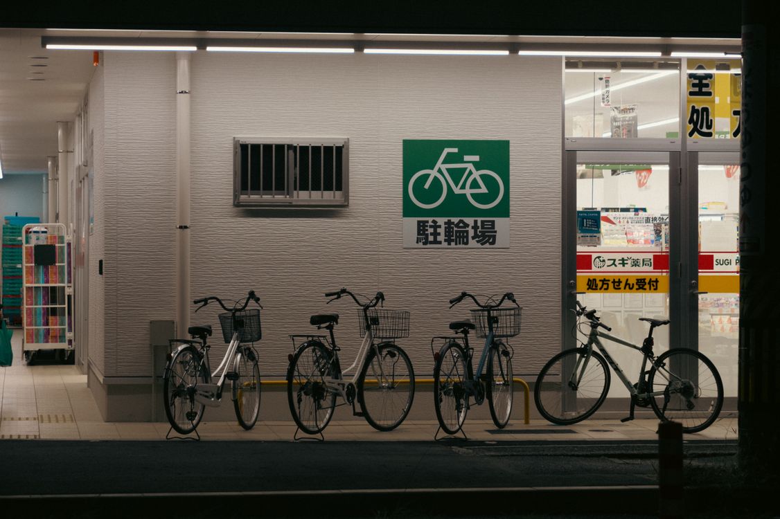 Japanese bicycle parking area with 駐輪場 sign at night