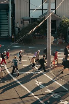 Aerial view of pedestrians, including school children, crossing a street in Toyokawa, Japan.
