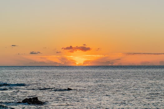 Breathtaking Hawaii sunset with vibrant orange hues over the calm Pacific Ocean.