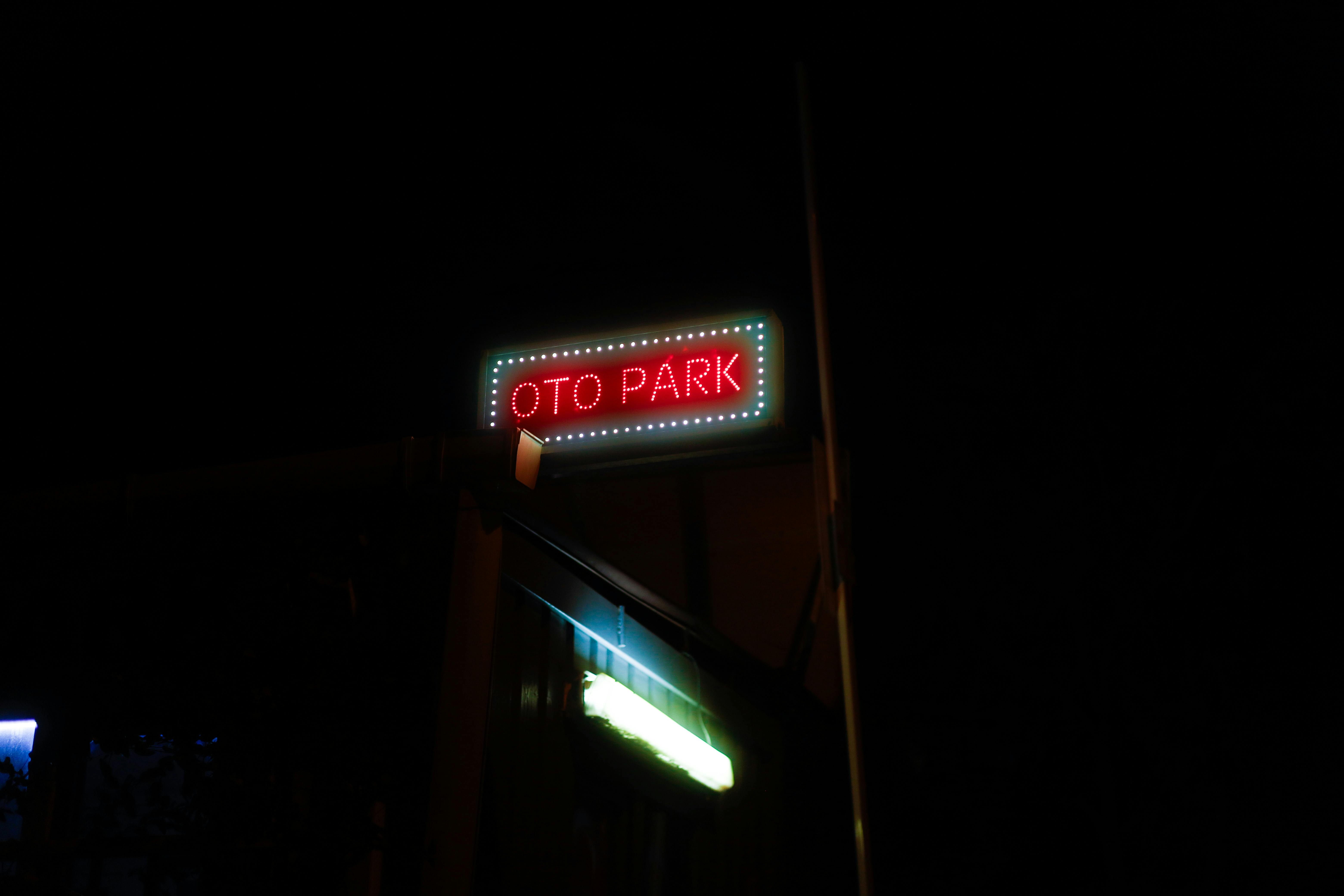 Gratuit O pancartă neon vibrantă cu „Oto Park” strălucind pe cerul nopții, înconjurat de întuneric. Fotografie de stoc