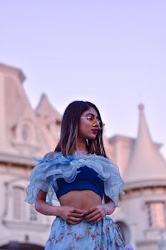 一位身着花卉服装的时尚女子在历史建筑外摆姿势