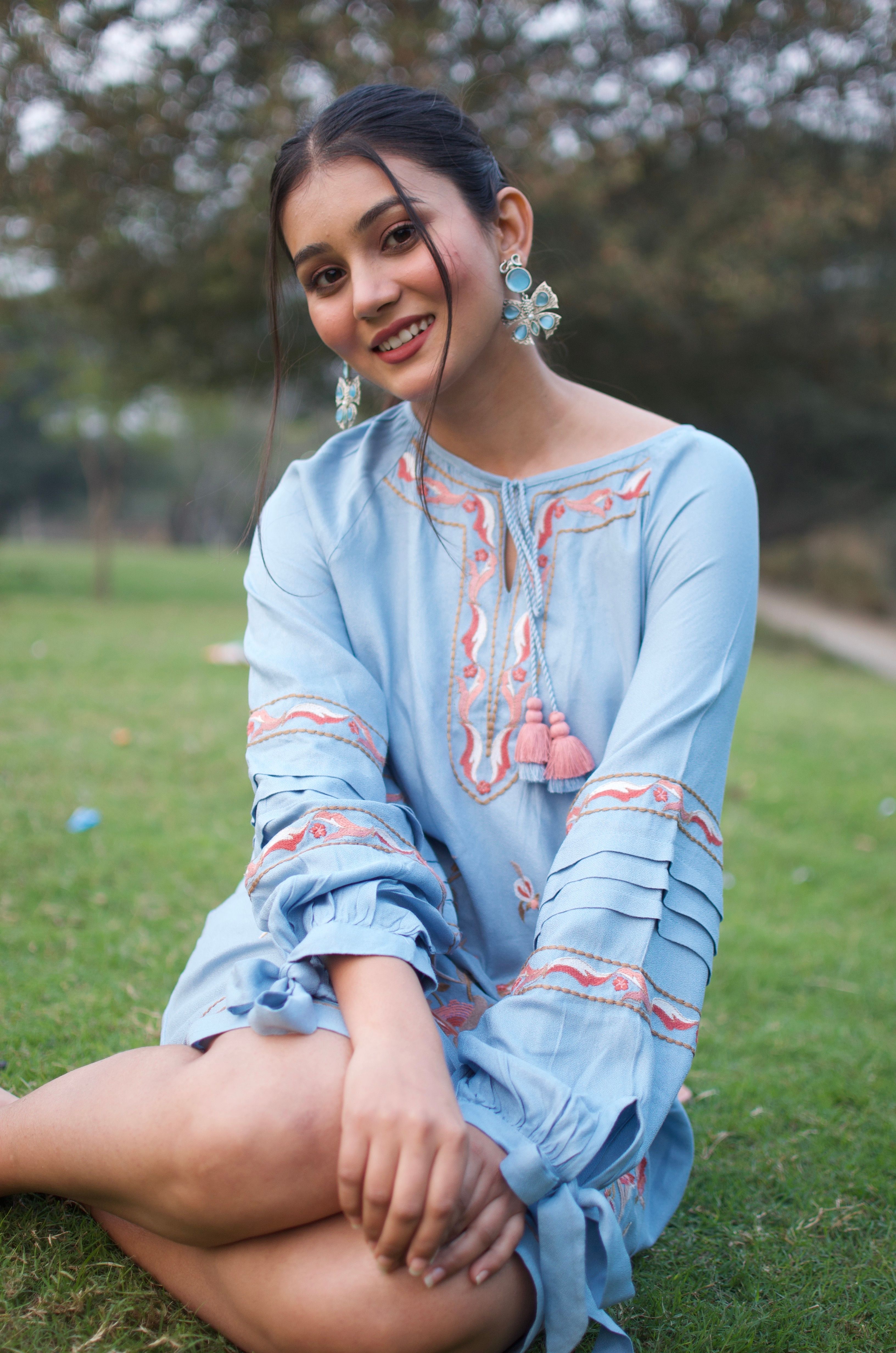 Young Woman in Traditional Dress Smiling Outdoors · Free Stock Photo