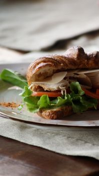 A delicious croissant sandwich filled with turkey, lettuce, and tomato slices, perfect for a quick meal.