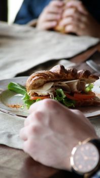 A fresh sandwich with greens and turkey on a rustic table setup.