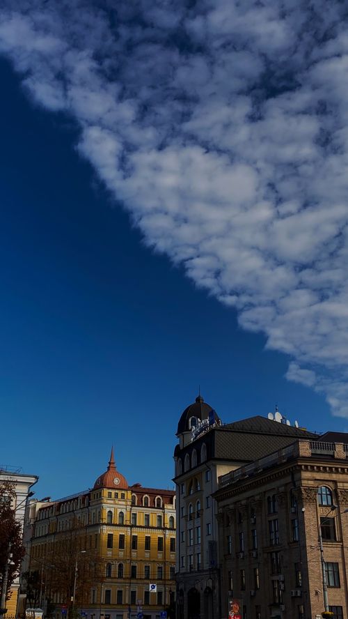 Free Classic European buildings with ornate architecture under a vibrant blue sky and cloudscape. Stock Photo