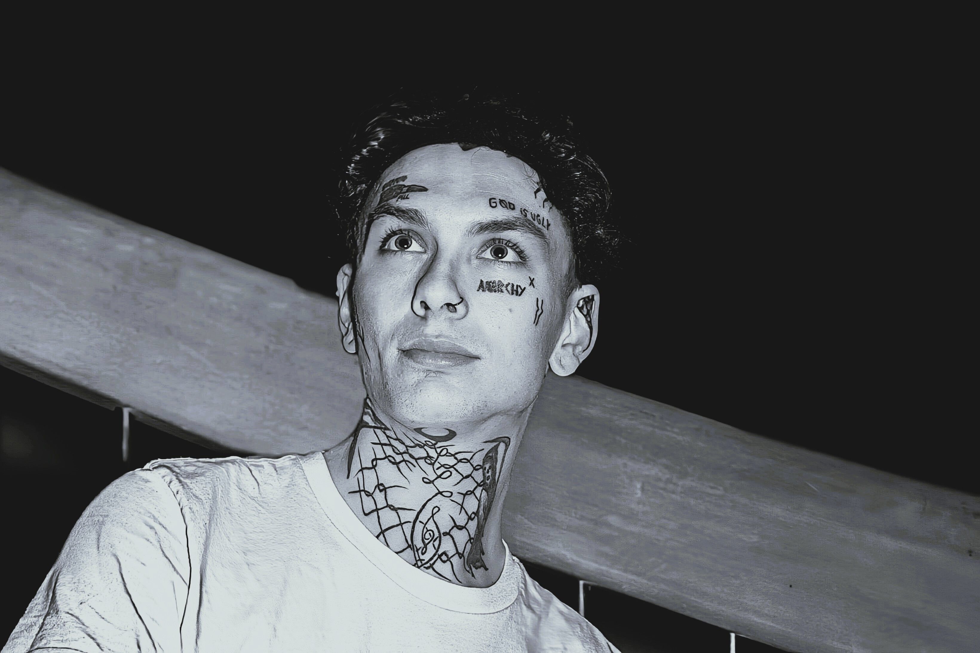 Artistic monochrome portrait of a person with facial tattoos and unique style, captured at night.