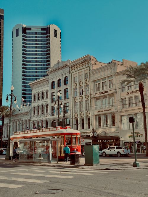Free Streetcar in front of historic buildings in New Orleans, capturing vibrant urban life. Stock Photo