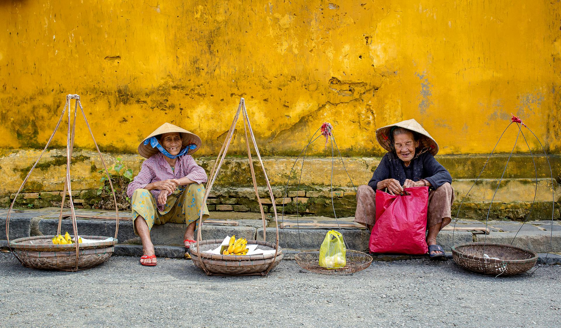 Vibrant scene of elderly street vendors in Hội An, Vietnam.