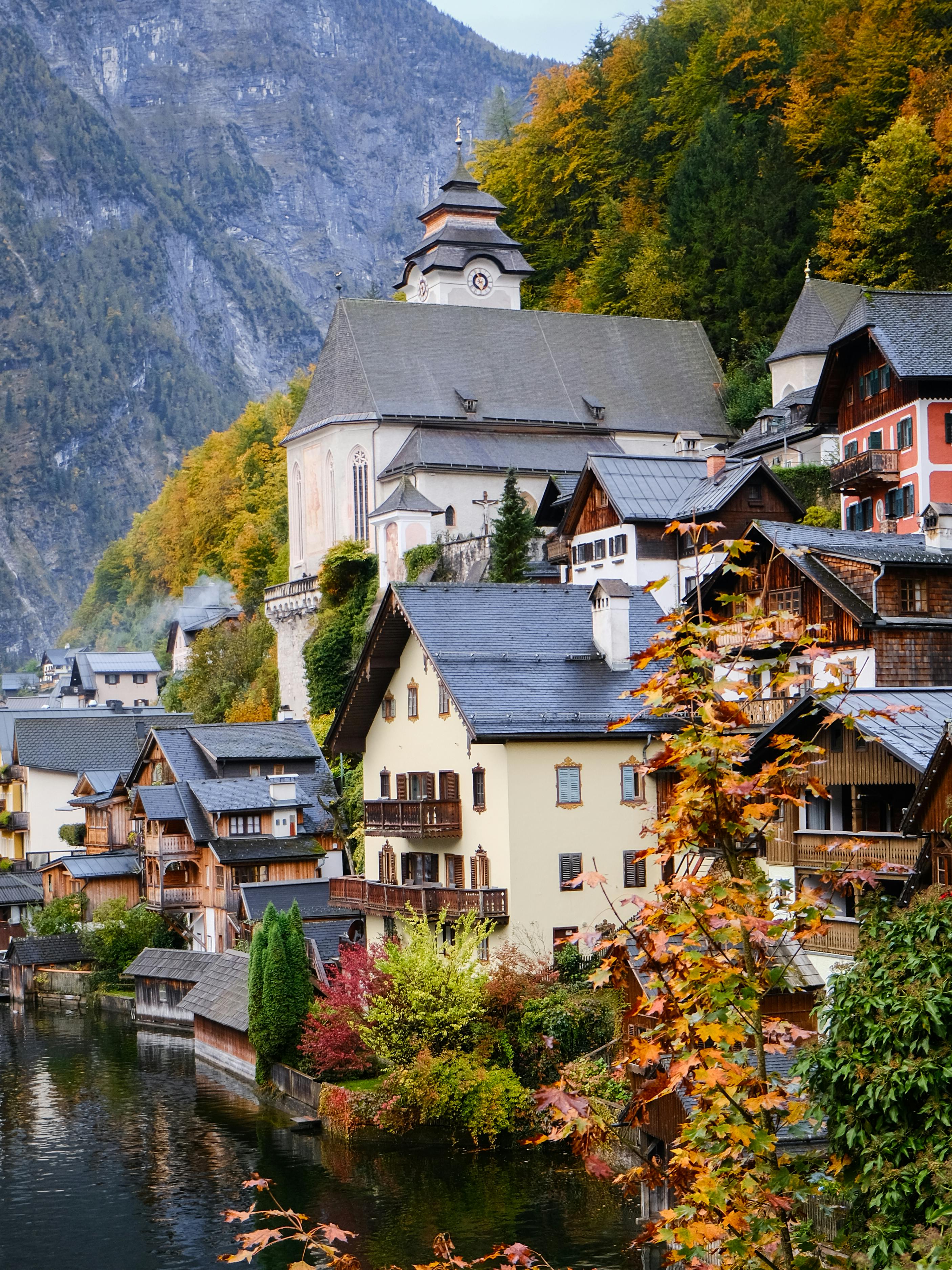 Explore the quaint alpine village of Hallstatt with its vibrant autumn colors and traditional architecture.
