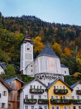 Picturesque view of Hallstatt's quaint architecture amidst vibrant autumn foliage in Austria.