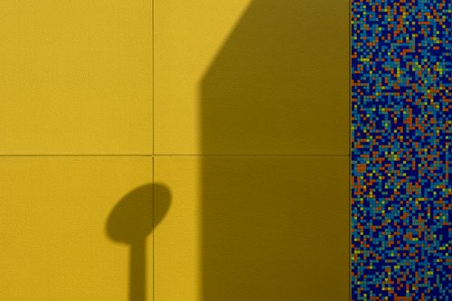 Free Artistic shadow on a textured yellow wall with vibrant mosaic pattern. Stock Photo