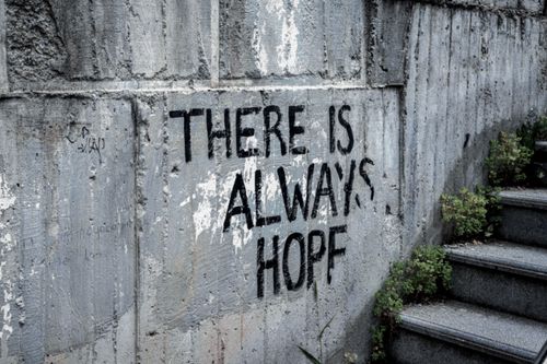 Free Graffiti on concrete wall reads 'There is always hope' next to outdoor stairs. Stock Photo
