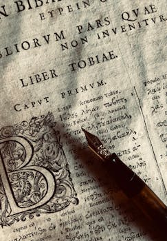 Close-up of ancient Latin script with a fountain pen on aged paper.