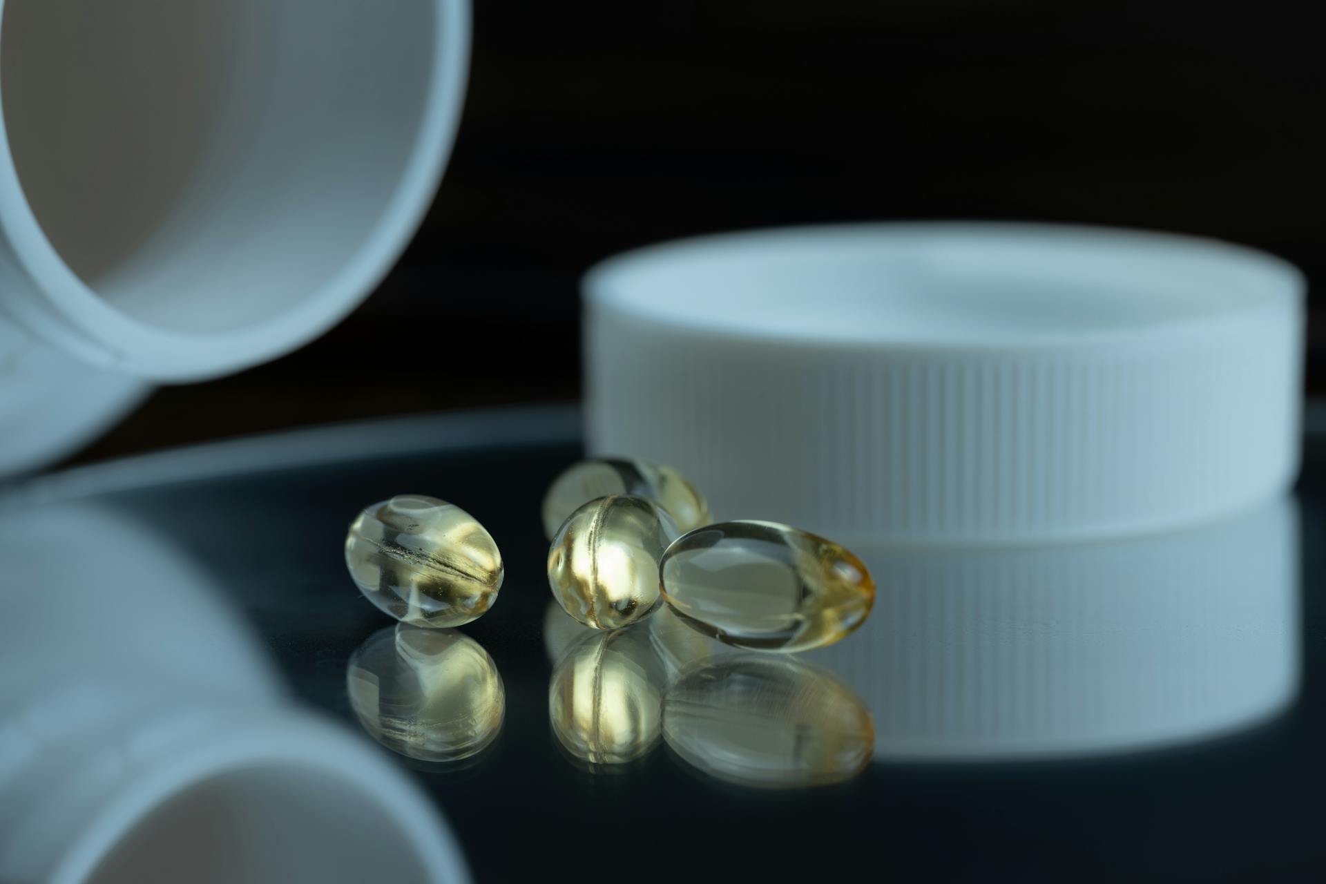 Focused image of gel capsules with a white bottle cap, emphasizing health and supplements.