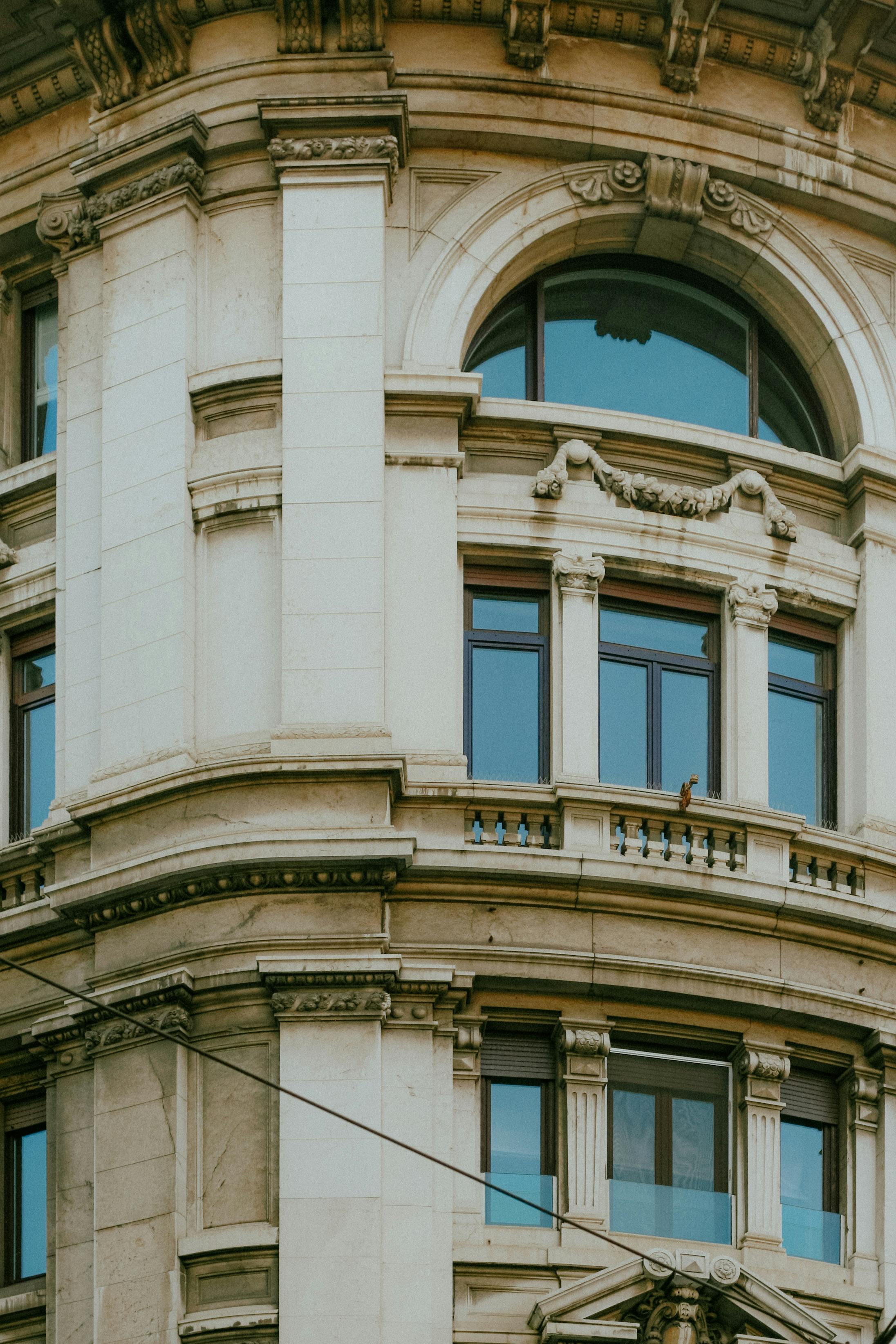Close-up of architectural details on a historic building facade in Milan, showcasing ornate window arches.