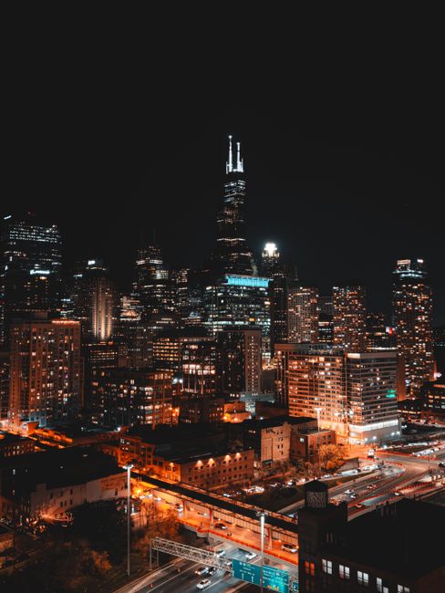 Stunning night view of Chicago skyline with glowing city lights and high-rise buildings.
