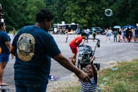 节日里，一家人在户外度过，孩子们玩耍着，色彩缤纷的泡泡四处漂浮