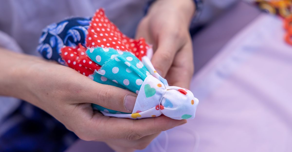 Close-up of hands holding vibrant, patterned fabric pieces for crafting.