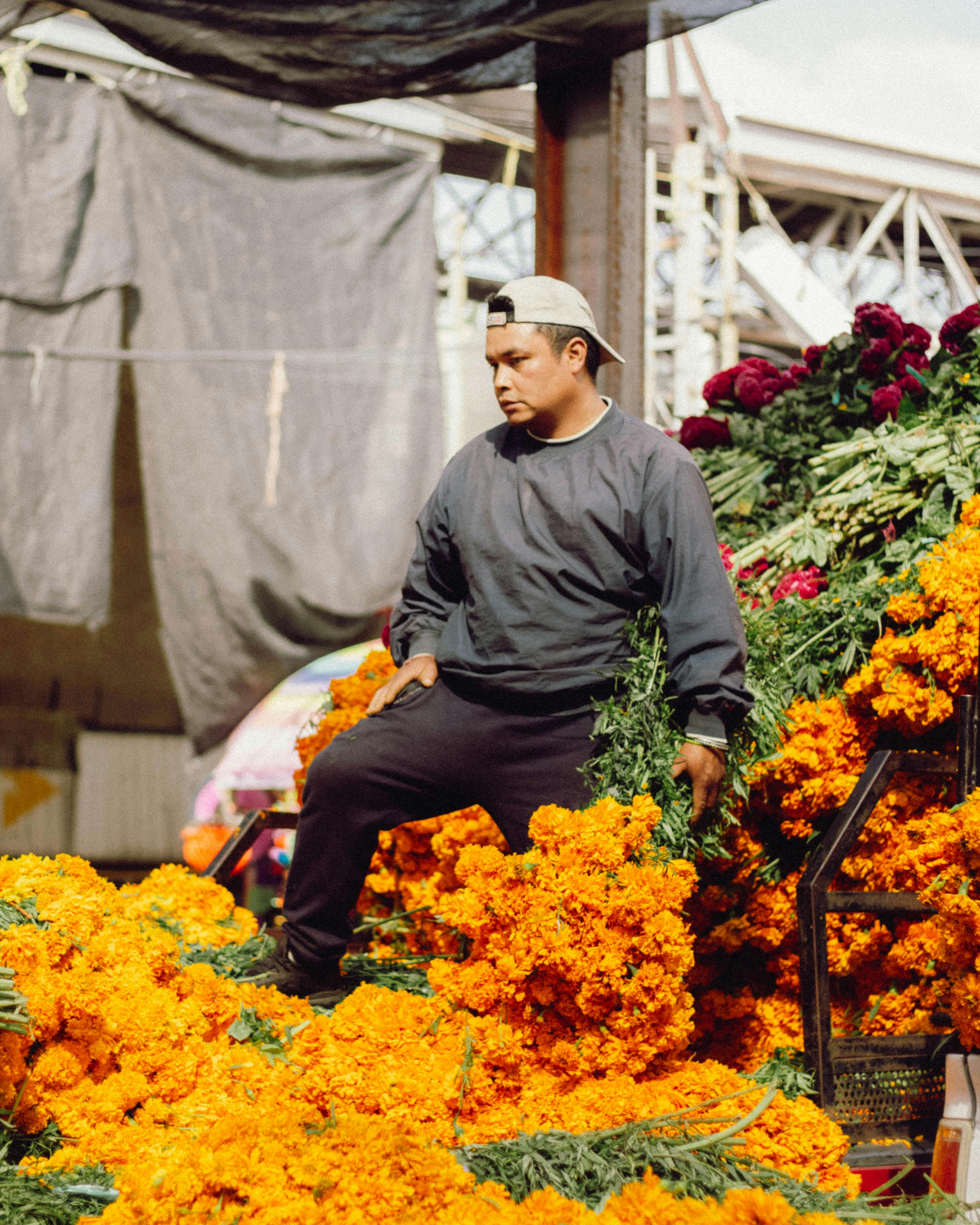 man selling marigolds at mexican market