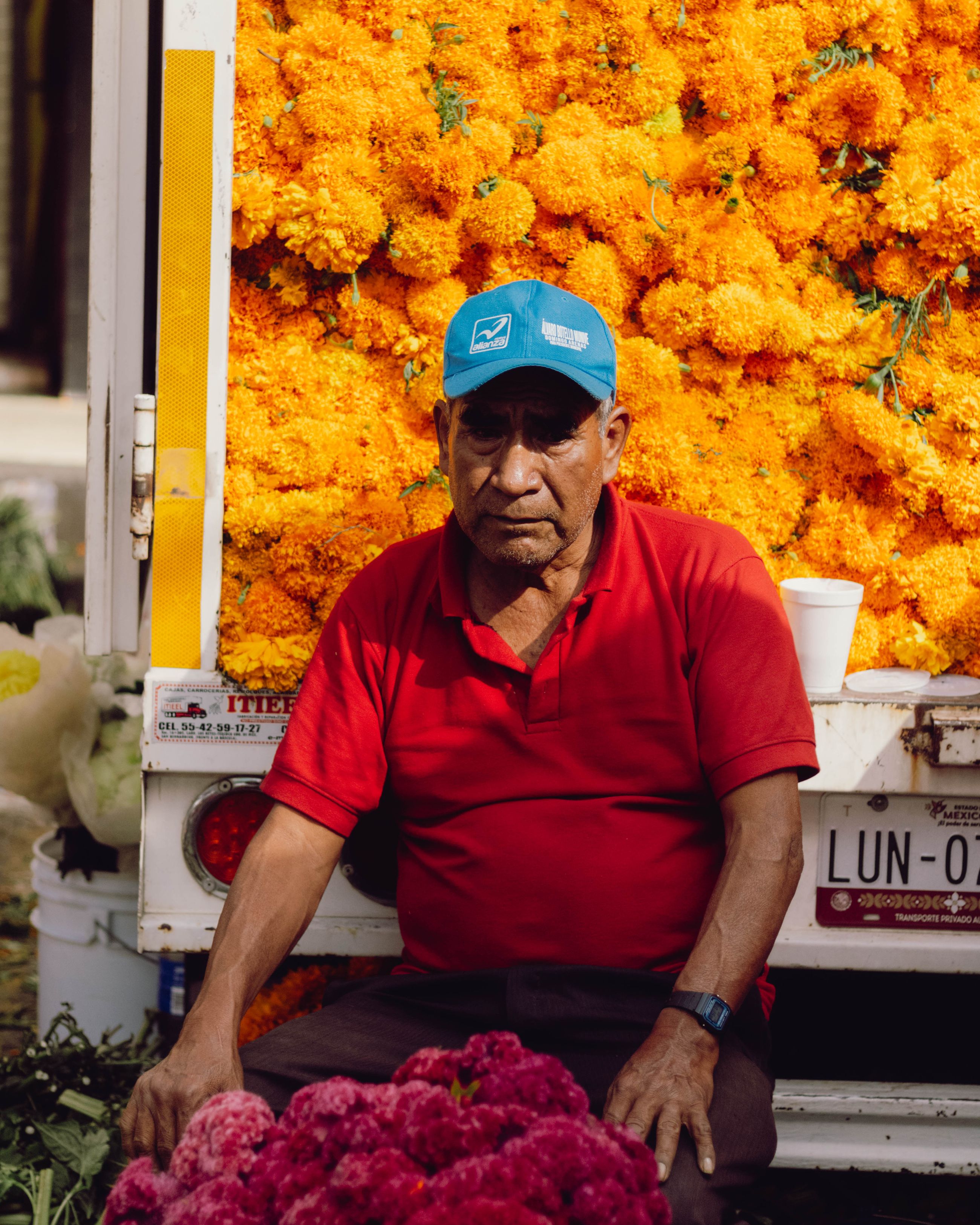 Vendor selling cempasuchil marigolds at a Mexican market before Día de Muertos