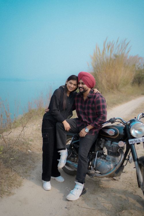 Free Happy couple posing with a motorcycle by a river in Himachal Pradesh, India. Stock Photo