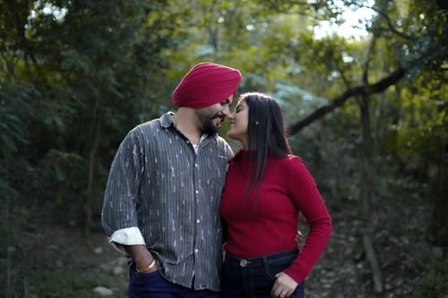 Free A couple lovingly embraces in a lush forest, exuding warmth and affection. Stock Photo