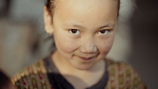 Close-up portrait of a smiling child with warm lighting, evoking happiness and innocence.