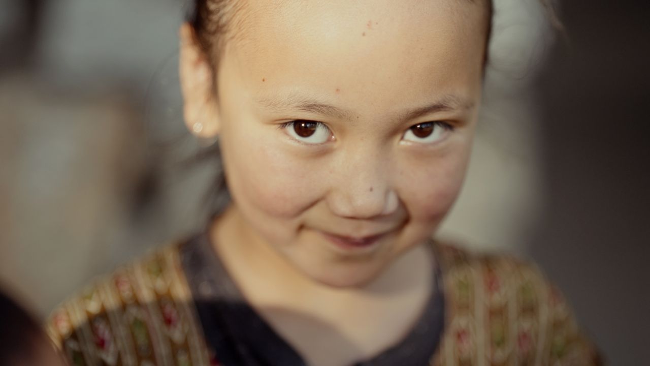 close up portrait of a smiling child with warm lighting evoking happin