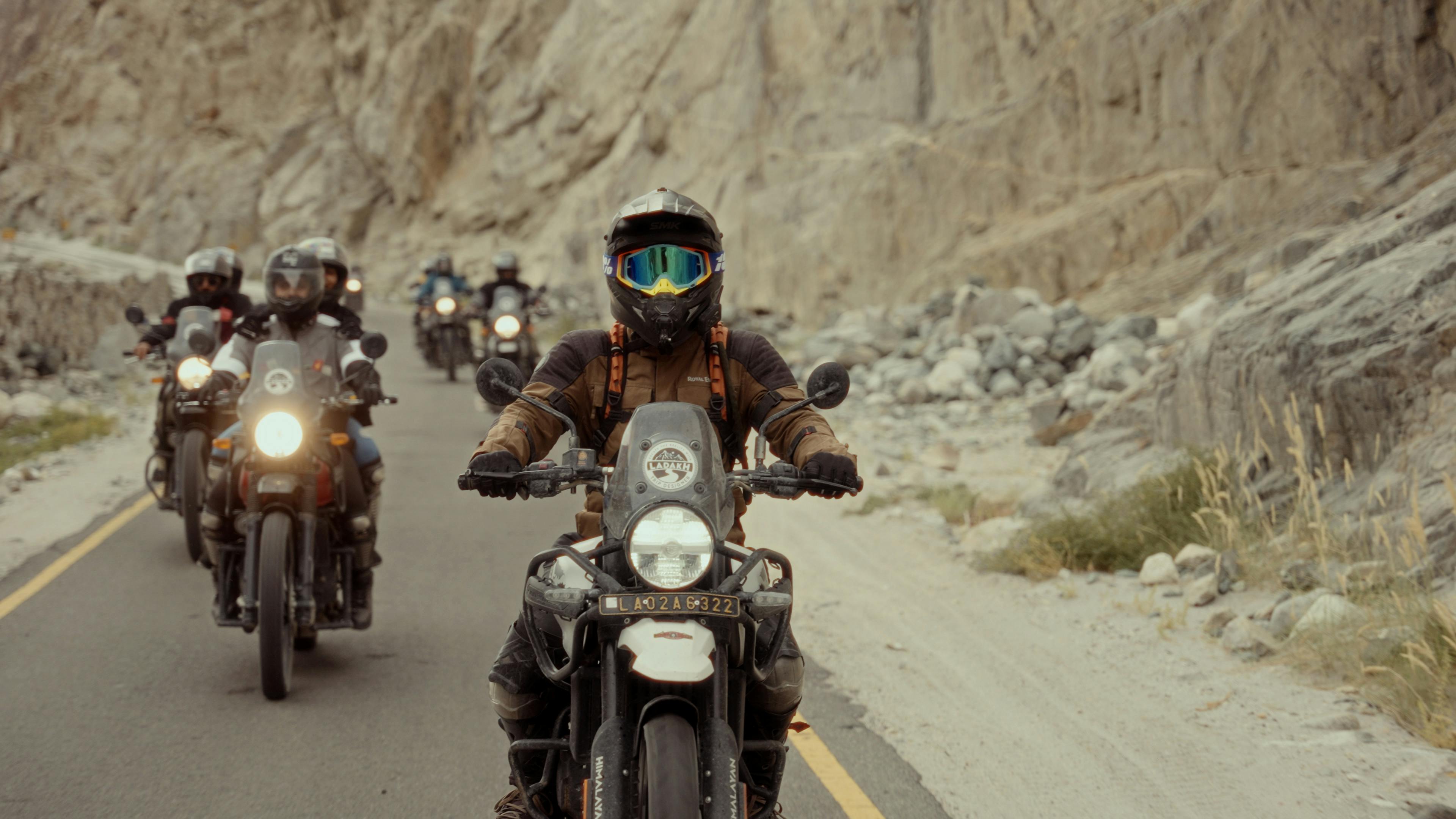 Group of motorcyclists riding through scenic mountain roads, showcasing adventure and freedom.