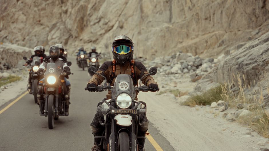 Group of motorcyclists riding through scenic mountain roads, showcasing adventure and freedom.