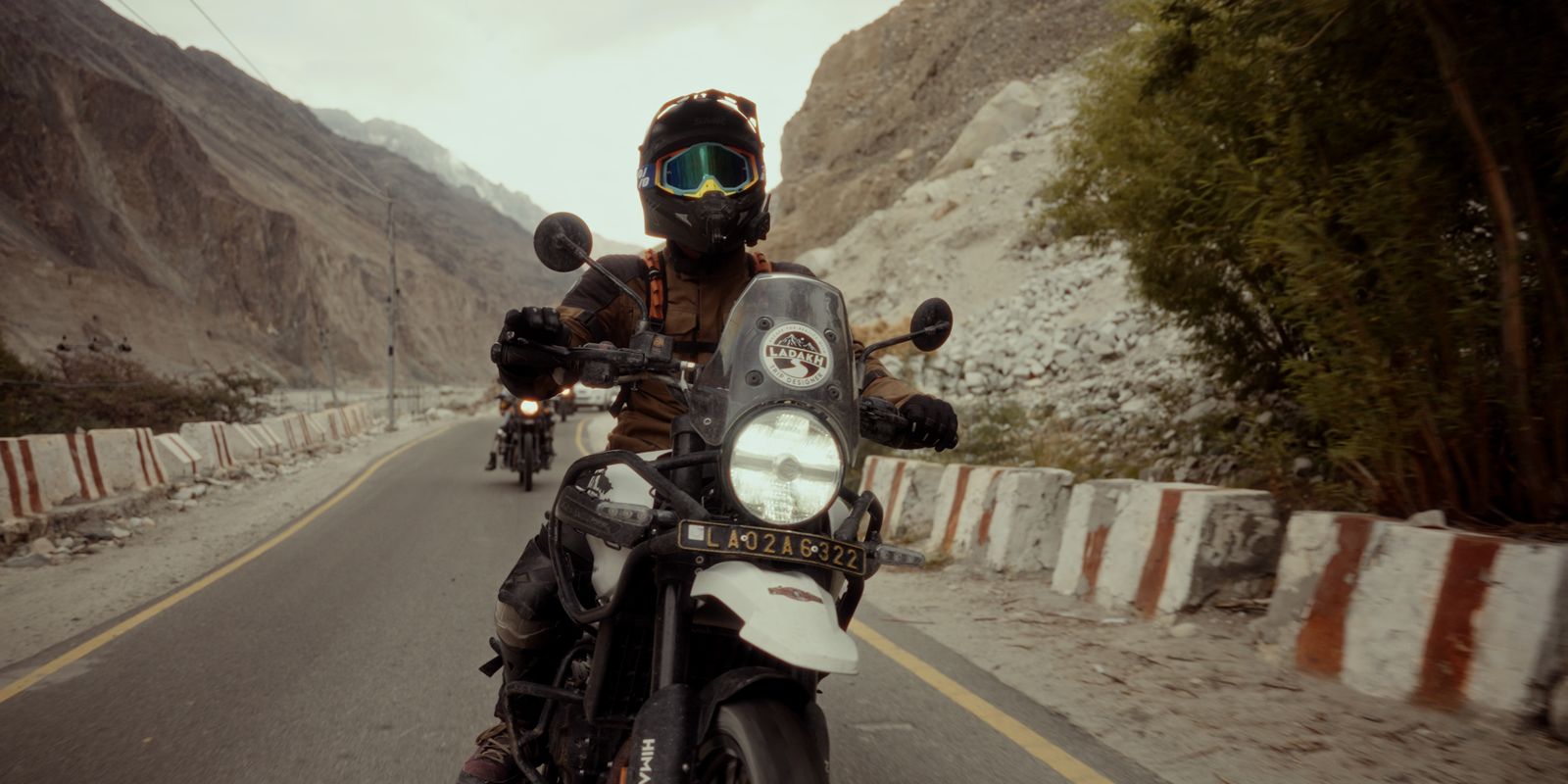 A motorcyclist riding through rugged mountain roads