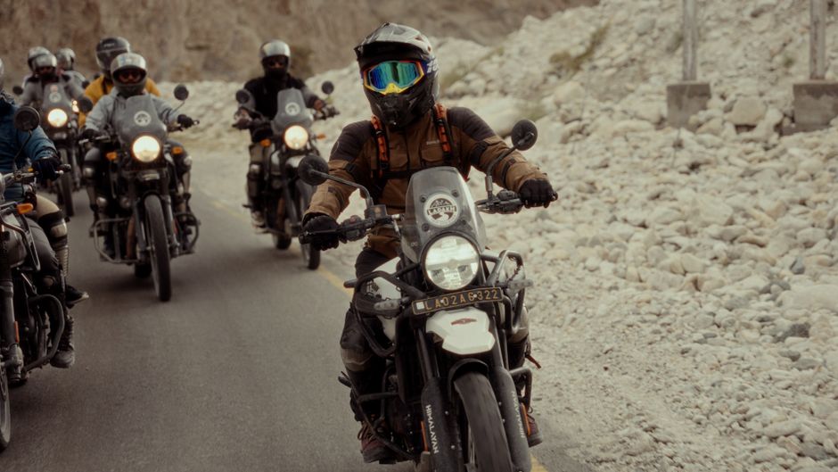 A group of motorcyclists ride through a rocky terrain, showcasing adventure and camaraderie.