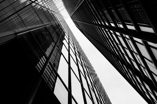 Dramatic black and white shot of symmetrical high-rise buildings.