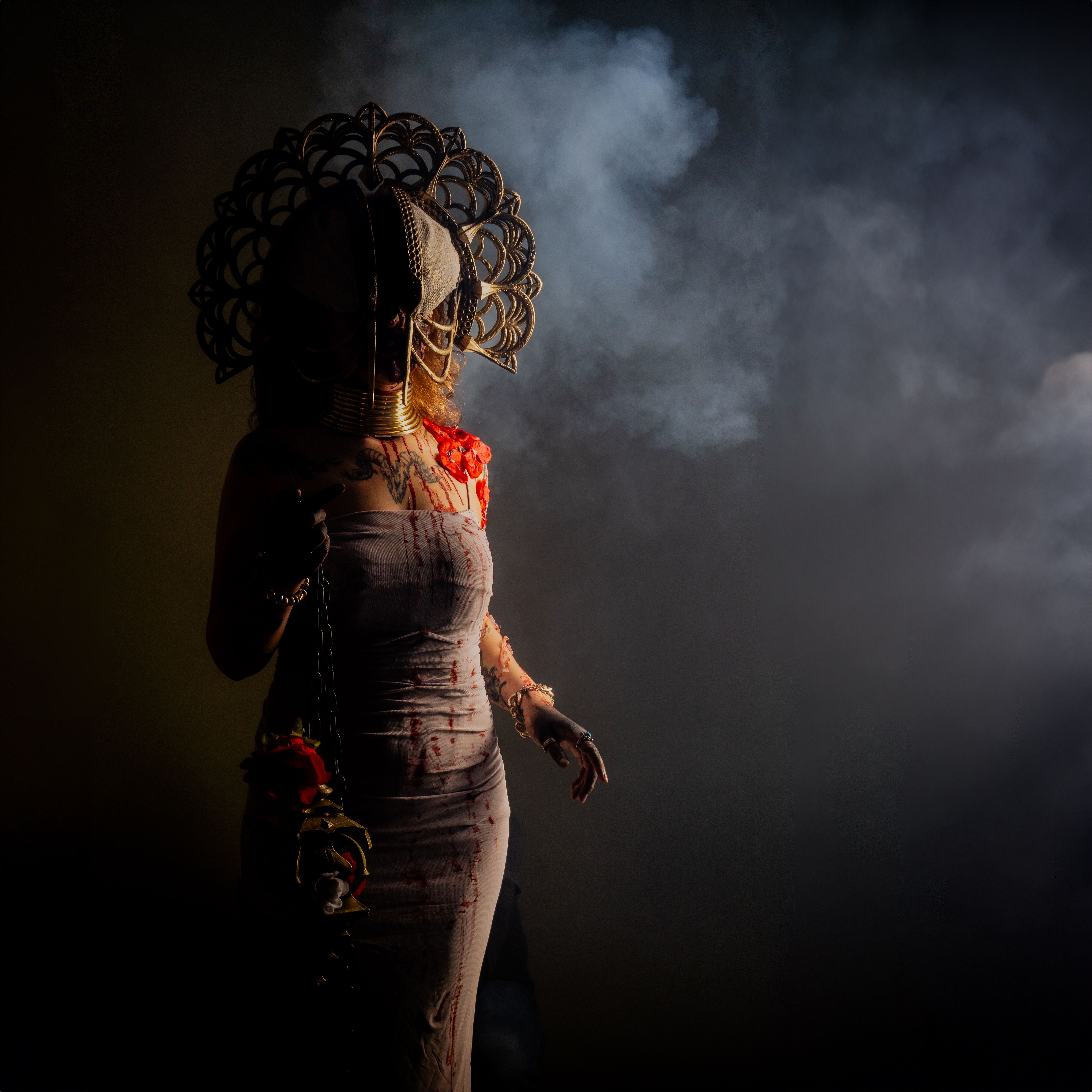 Dark and mysterious figure in an elaborate Halloween costume, enveloped in smoke.