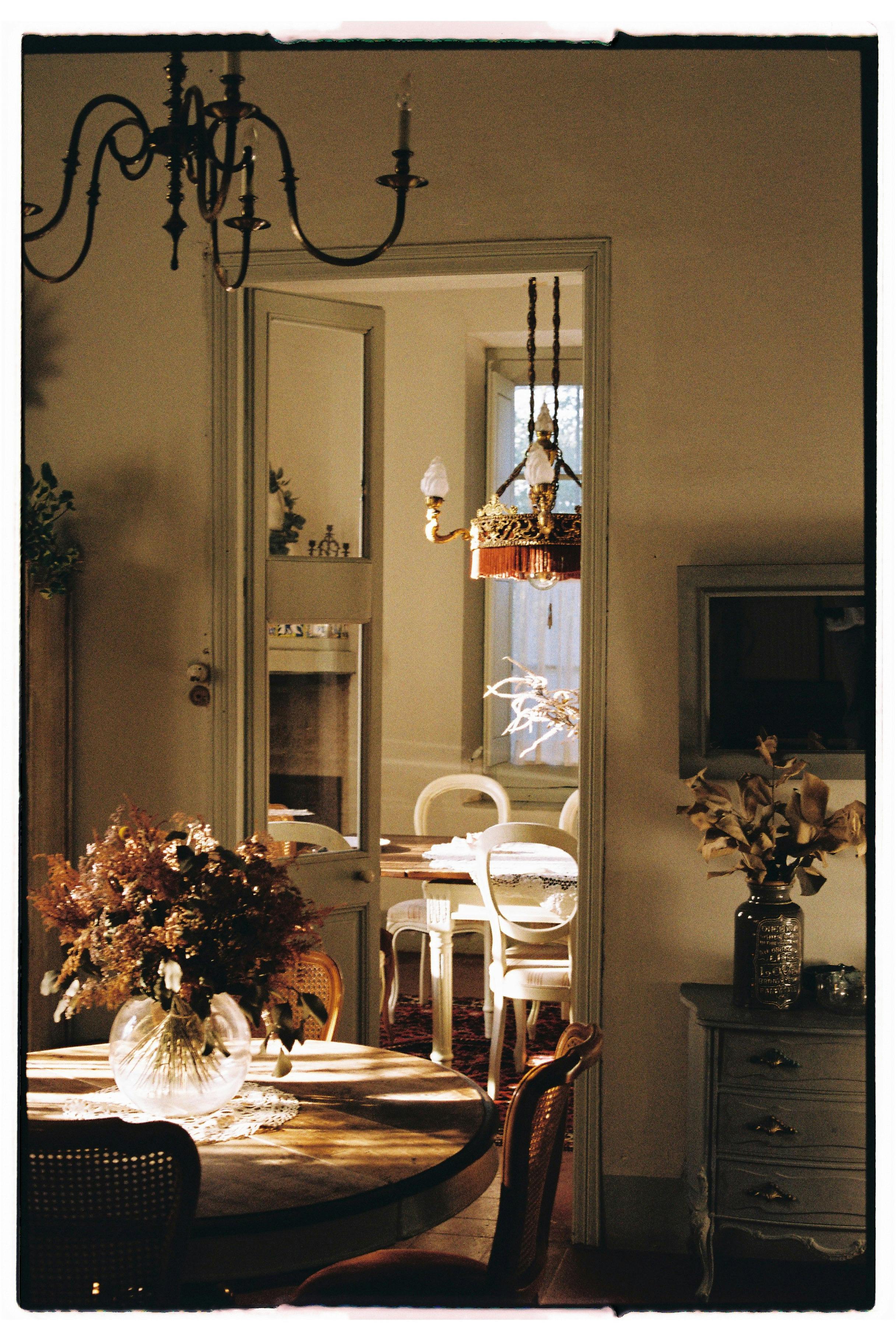 Warm vintage dining room featuring floral arrangements and soft natural light.